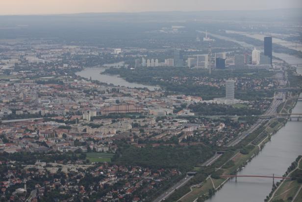 Luftaufnahme von Wien mit der Donau und der Donau City im Hintergrund.