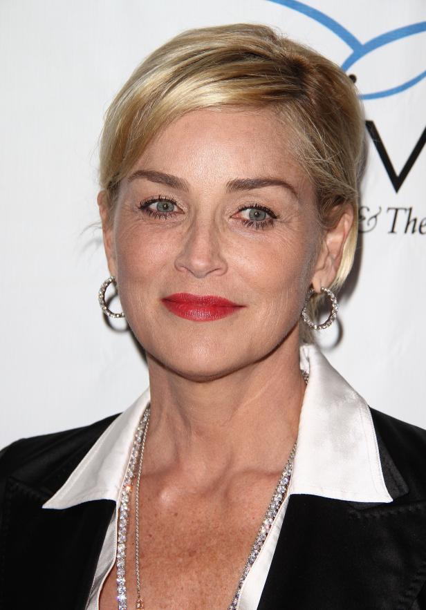 Ein Porträt von Sharon Stone mit blonden Haaren und rotem Lippenstift.