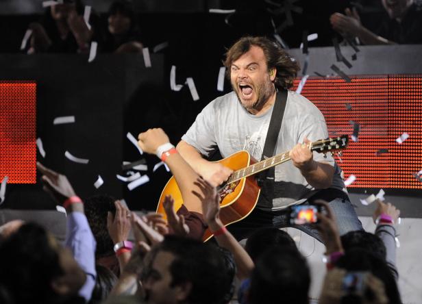 Jack Black spielt Gitarre auf einer Bühne vor einem jubelnden Publikum.