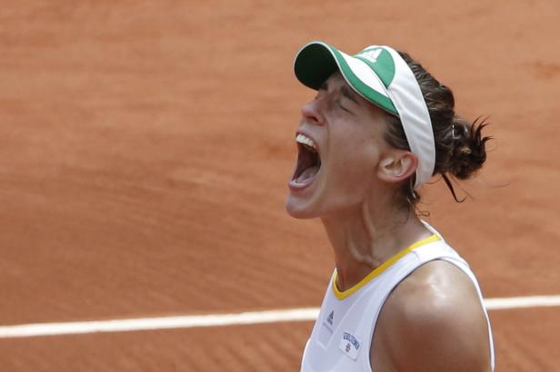 Andrea Petkovic of Germany reacts after winning he Eine Tennisspielerin schreit auf einem Sandplatz vor Anstrengung oder Freude.