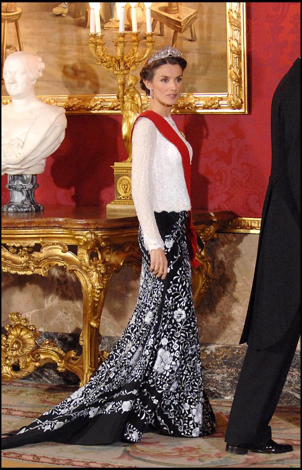 Königin Letizia trägt ein elegantes Kleid und eine Tiara in einem opulenten Raum.