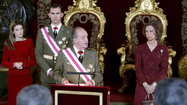 König Juan Carlos hält eine Rede, während Königin Sofia, König Felipe und Königin Letizia zuhören.