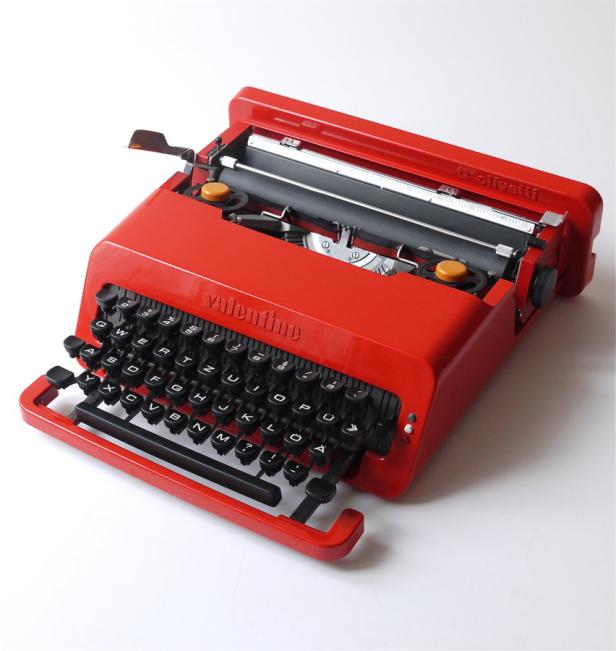 Eine rote Olivetti Valentine Schreibmaschine auf einem weißen Hintergrund.