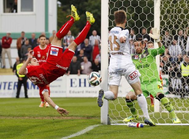Ein Fußballspieler erzielt mit einem Fallrückzieher ein Tor.