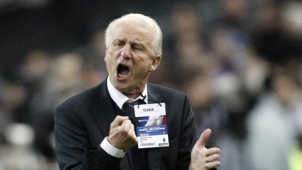 Ein Mann in einem Anzug gestikuliert und schreit auf dem Spielfeld.