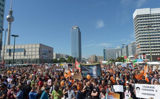 Eine große Menschenmenge demonstriert in Berlin vor dem Fernsehturm und anderen Hochhäusern.