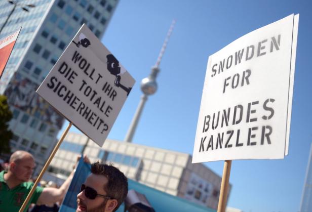 Demonstranten halten Schilder mit der Aufschrift „Wollt ihr die totale Sicherheit?“ und „Snowden for Bundeskanzler“.