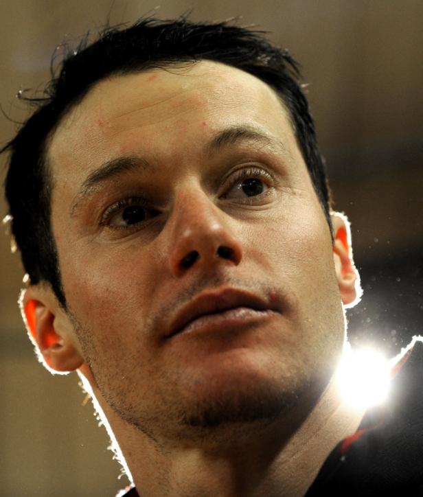 Nahaufnahme eines Mannes mit dunklen Haaren, der nach oben blickt.