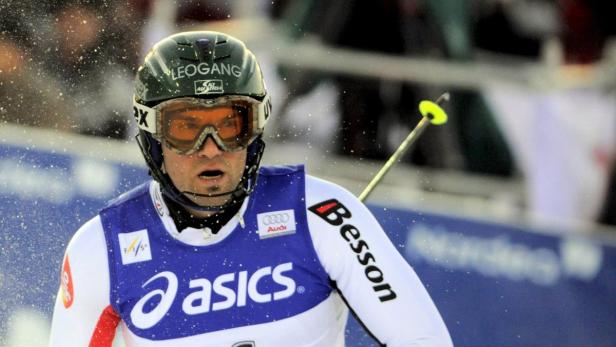 Ein Skirennläufer mit Helm und Skibrille während eines Rennens.