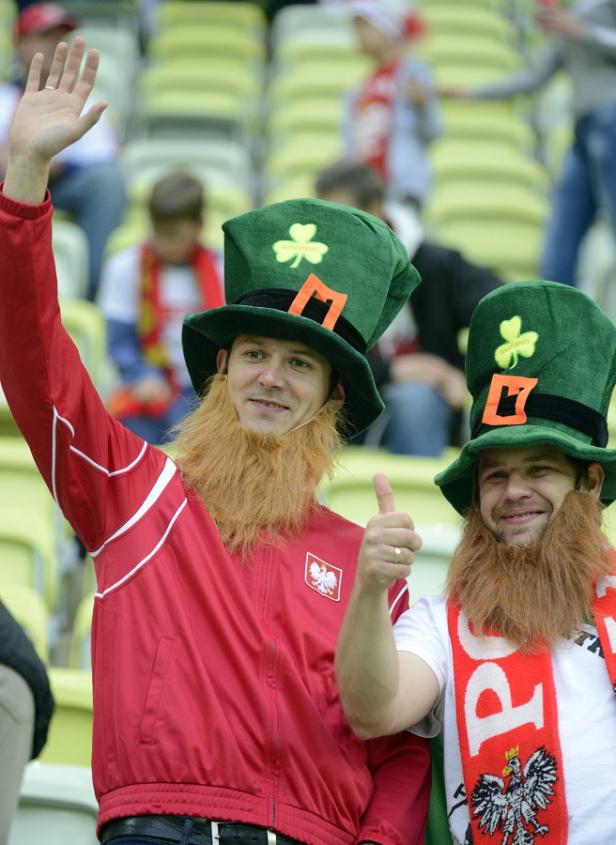 Zwei polnische Fans mit irischen Hüten und Bärten im Stadion.