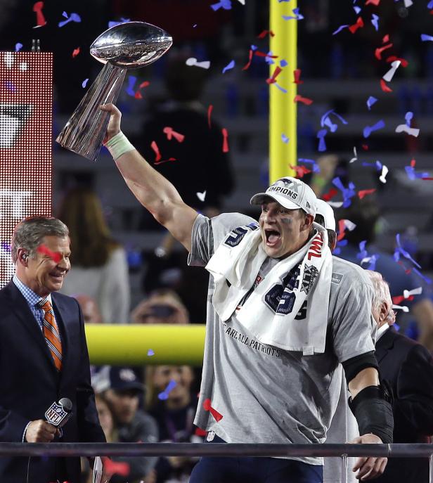 Ein Footballspieler der New England Patriots feiert mit der Vince-Lombardi-Trophäe.