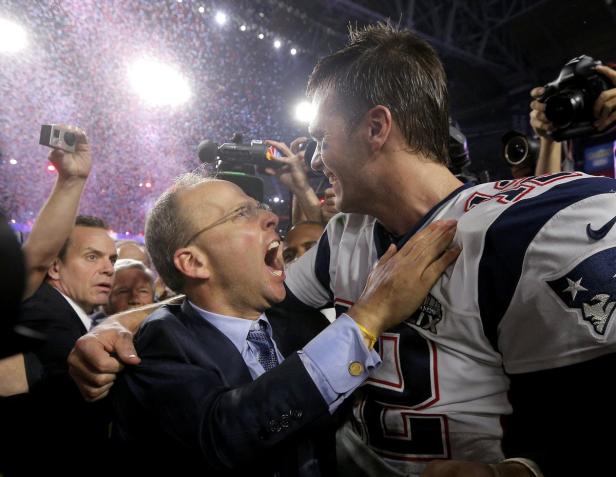 Tom Brady wird nach dem Super Bowl Sieg von einem Mann im Anzug umarmt.