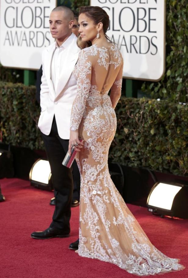 Jennifer Lopez in einem transparenten, weißen Spitzenkleid auf dem roten Teppich.