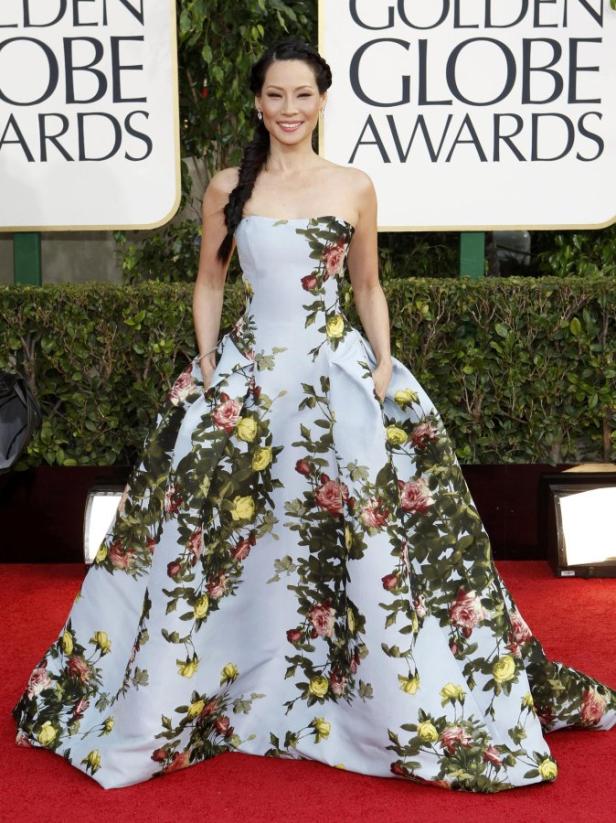 Lucy Liu in einem blassblauen, blumenbedruckten Kleid auf dem roten Teppich.