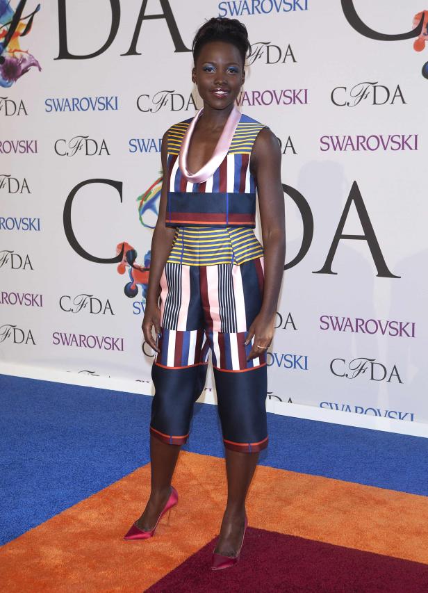 Lupita Nyong'o auf dem roten Teppich in einem farbenfrohen, gestreiften Outfit.