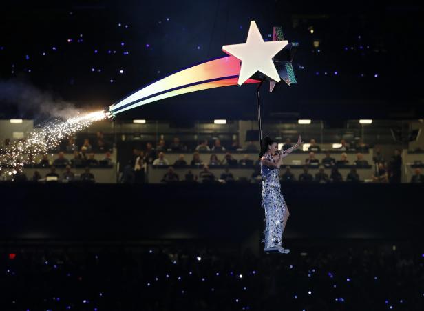 Katy Perry schwebt während einer Performance an einem Stern hängend über der Bühne.