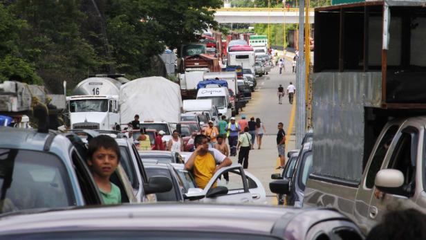 Eine lange Schlange von Autos und Lastwagen staut sich auf einer Straße.