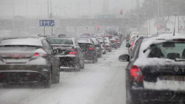 Schneefall behindert den Verkehr auf einer städtischen Straße.