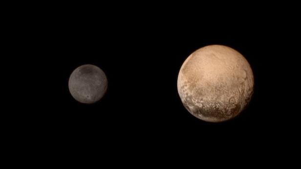 Eine Aufnahme von Pluto und seinem größten Mond Charon vor einem schwarzen Hintergrund.