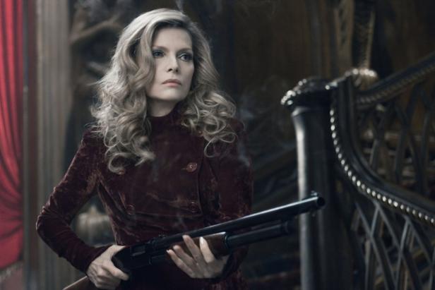 Michelle Pfeiffer hält in ihrer Rolle als Louella Parsons eine Schrotflinte.
