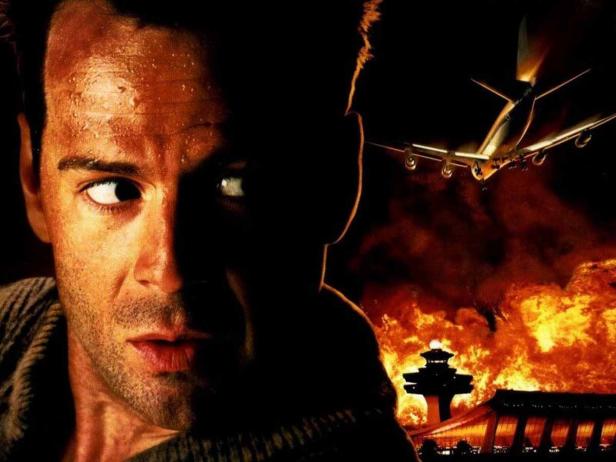 Bruce Willis in „Stirb Langsam 2“ vor einem brennenden Flughafen.
