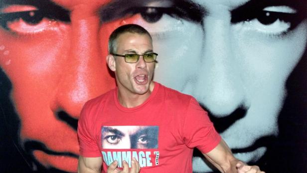 Jean-Claude Van Damme vor einem Poster des Films „Damage“.