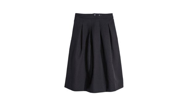 Eine schwarze, plissierte A-Linien-Rock vor einem weißen Hintergrund.