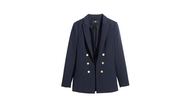 Ein marineblauer Blazer mit goldenen Knöpfen vor einem weißen Hintergrund.