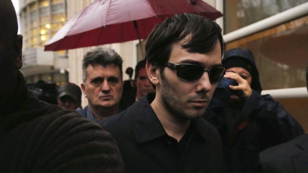 Martin Shkreli verlässt unter einem roten Regenschirm ein Gerichtsgebäude.