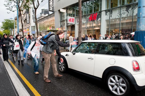 Eine Gruppe als Zombies verkleideter Menschen läuft auf einer Straße entlang.