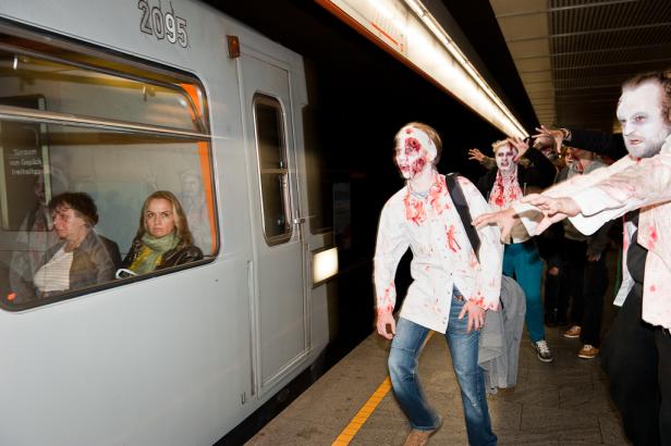 Eine Gruppe als Zombies verkleideter Menschen greift Fahrgäste in einer U-Bahn an.