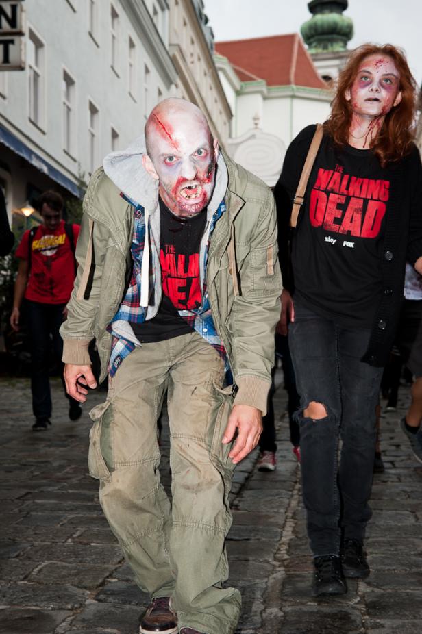 Zwei als Zombies verkleidete Personen nehmen an einer Parade teil.