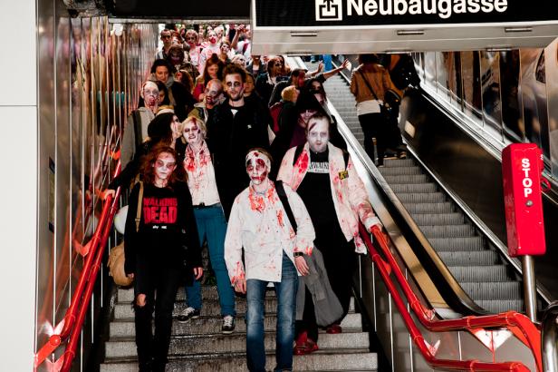Eine Gruppe als Zombies verkleideter Menschen auf einer Rolltreppe in der U-Bahn-Station Neubaugasse.