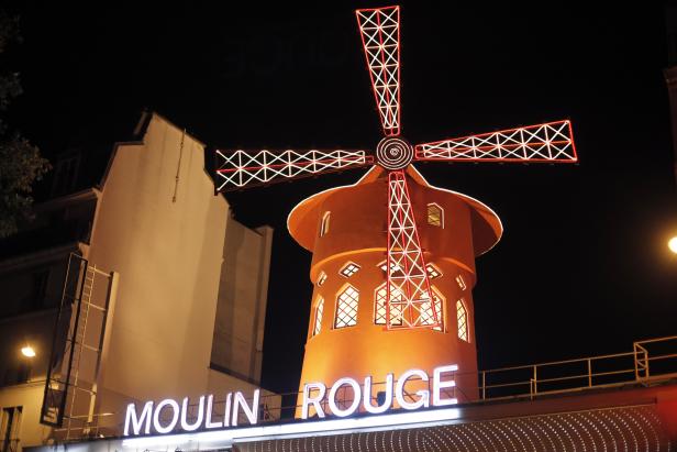 Das Moulin Rouge in Paris bei Nacht mit beleuchtetem Mühlrad.