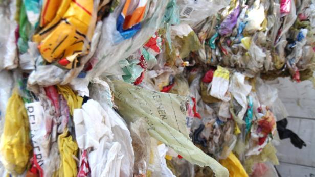 Ein großer Haufen von zusammengepressten Plastiktüten und Verpackungsabfällen.