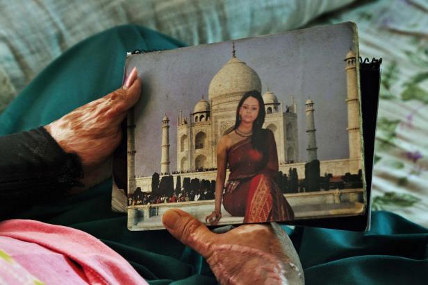 Eine Person hält ein Foto von einer Frau vor dem Taj Mahal.