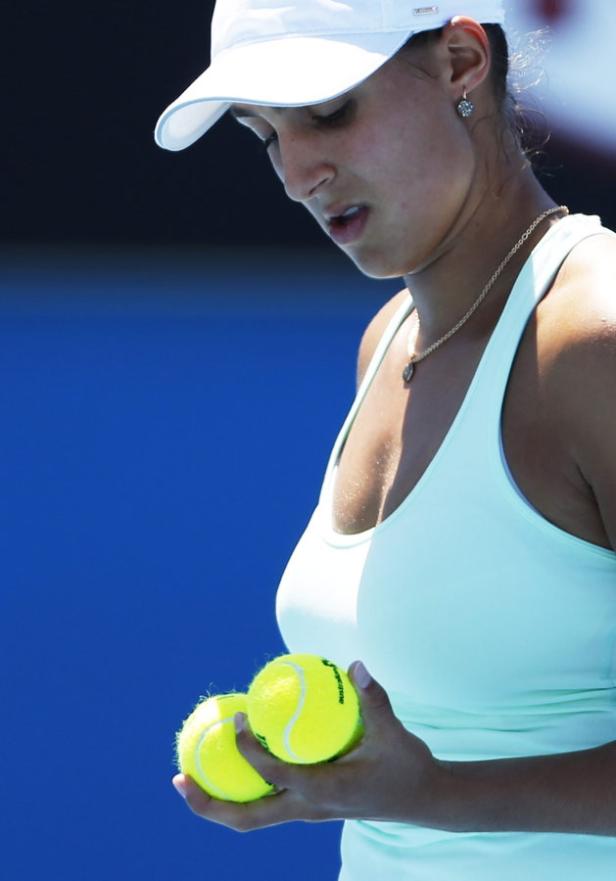 Eine Tennisspielerin hält zwei Tennisbälle in ihren Händen.