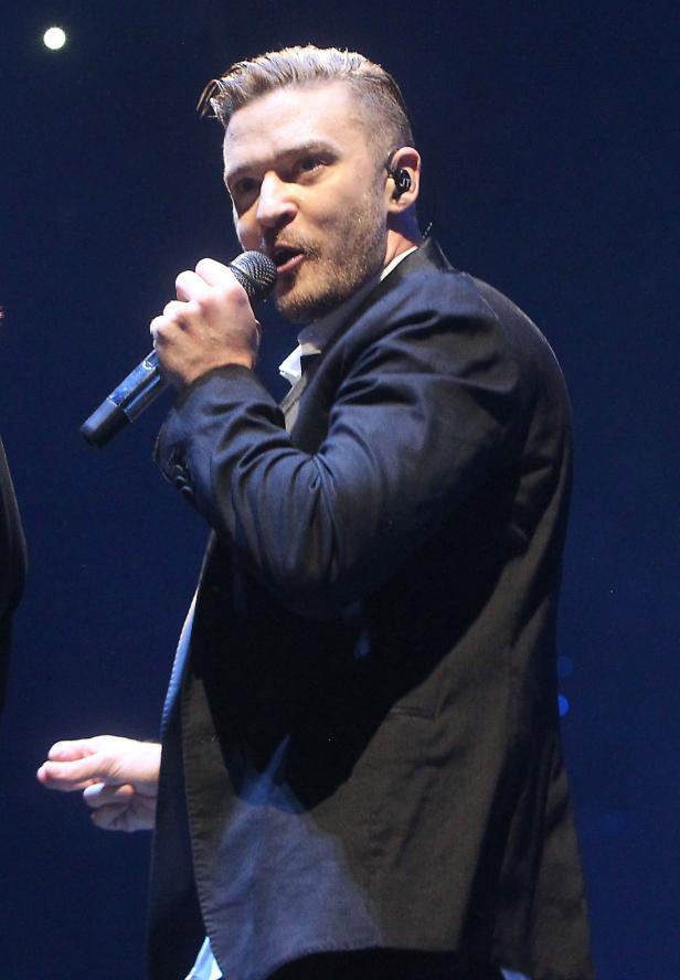 Justin Timberlake singt in einem schwarzen Anzug auf der Bühne.