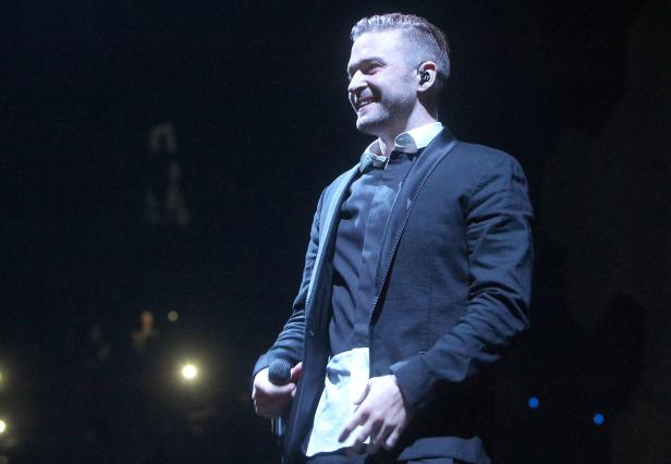 Justin Timberlake tritt auf der Bühne auf und lächelt.