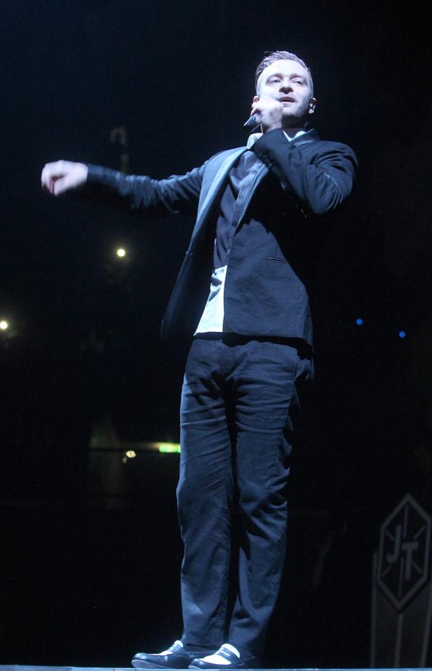 Justin Timberlake tritt in einem schwarzen Anzug auf der Bühne auf.