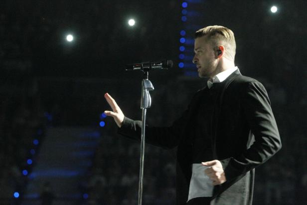 Justin Timberlake steht auf der Bühne und singt in ein Mikrofon.