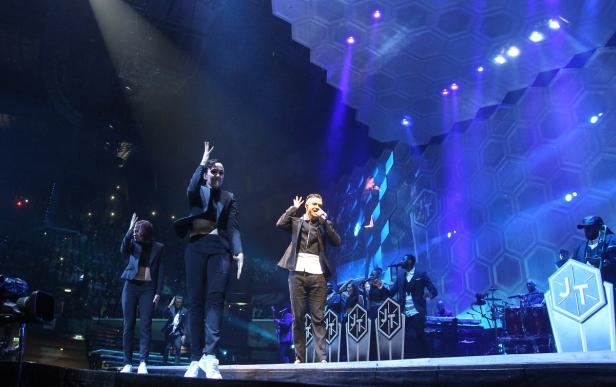 Justin Timberlake tritt mit Tänzern und Band auf einer Bühne auf.