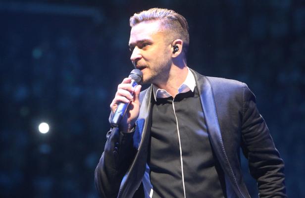 Justin Timberlake singt während eines Konzerts in ein Mikrofon.