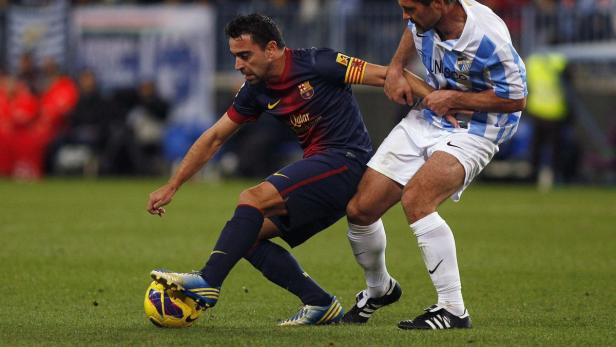 Xavi Hernández während eines Fußballspiels im Zweikampf.