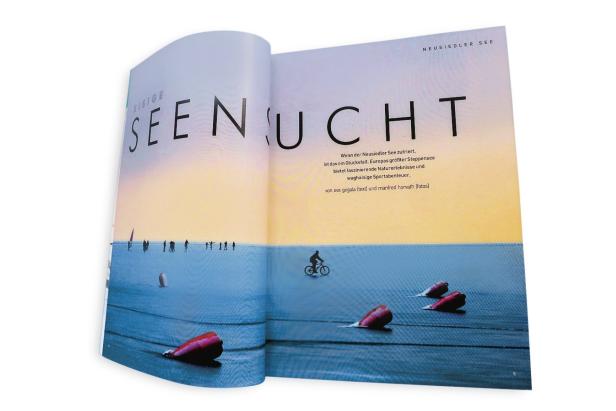 25 jahre freizeit… Ein aufgeschlagenes Magazin zeigt eine Szene auf dem zugefrorenen Neusiedler See mit Menschen und einem Radfahrer.
