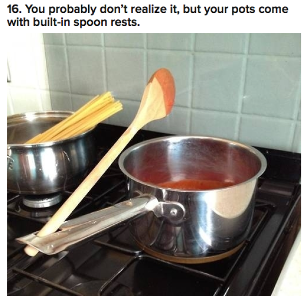 Auf einem Herd stehen zwei Töpfe, einer mit Spaghetti, der andere mit Tomatensoße, und ein Holzlöffel liegt quer über einem Topf.