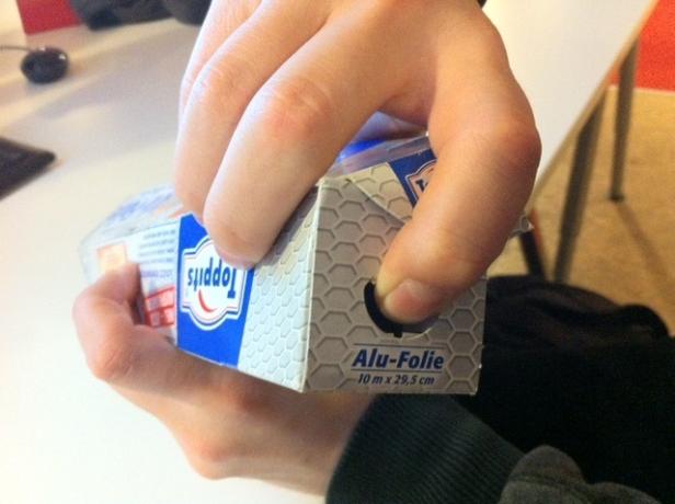 Eine Hand hält eine Packung „Toppits“ Alufolie.