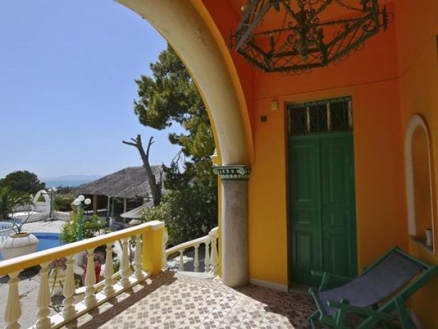 Ein Blick von einer Terrasse auf einen Pool und das Meer.