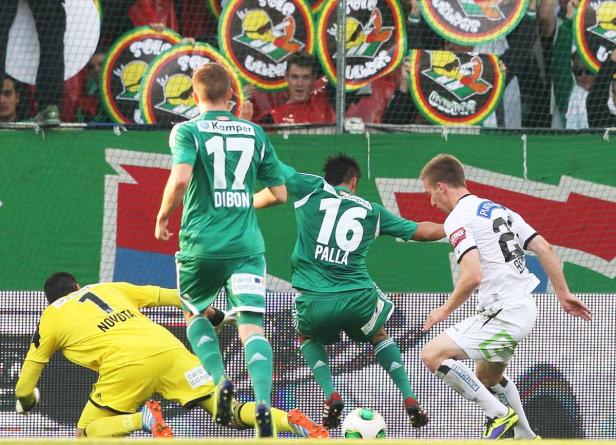Fußballspieler kämpfen um den Ball während eines Spiels.