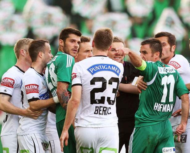Fußballspieler stehen während eines Spiels in einer Auseinandersetzung zusammen.
